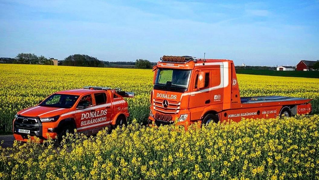 Två bärgningsbilar från Donalds bilbärgning på en rapsåker i skåne 